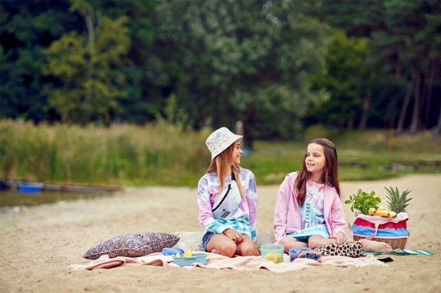 Deux filles assises sur une couverture sur la plage