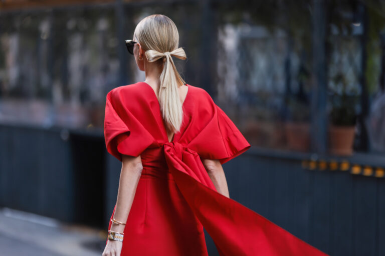 looks de Noël ; femme portant une robe rouge chic avec un nœud derrière