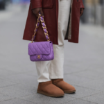 Bottes UGG basses marron, sac à main violet, pantalon blanc, manteau rouge foncé