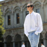 Mode masculine 2024 : mannequin portant une chemise blanche, une cravate blanche, un jean clair et des lunettes de soleil