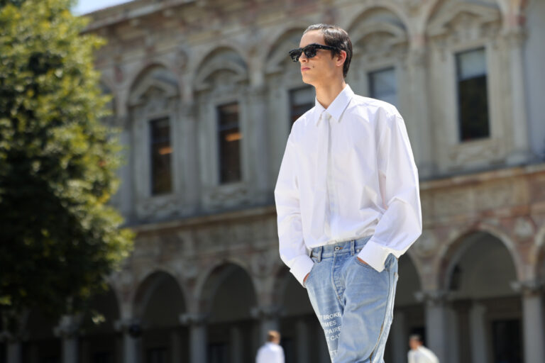 Mode masculine 2024 : mannequin portant une chemise blanche, une cravate blanche, un jean clair et des lunettes de soleil