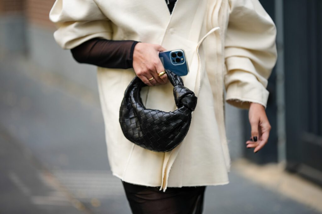Femme en manteau écru et sac à main noir