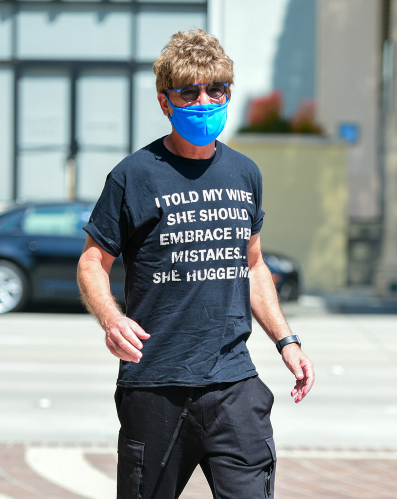 Homme portant un masque bleu et un t-shirt à imprimé