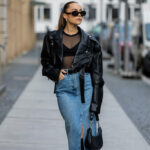 Femme dans une veste perfecto noire et une longue jupe en jean