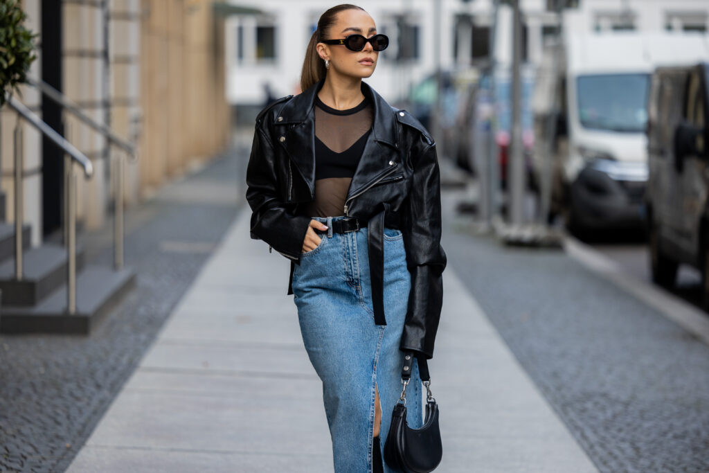 Femme dans une veste perfecto noire et une longue jupe en jean