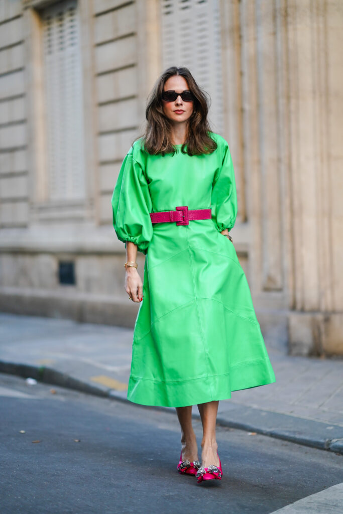 Femme portant une robe verte claire et des talons aiguilles couleur fuchsia